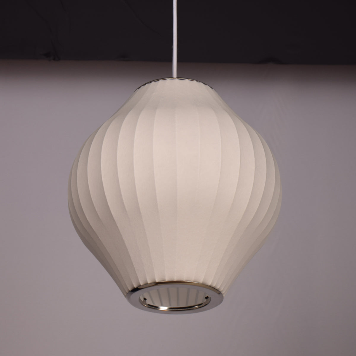 White ribbed pendant light against a dark background